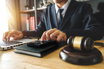 justice and law concept.businessman or lawyer or accountant working on accounts using a calculator...