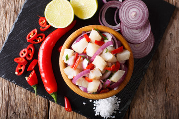 Healthy fish ceviche of cod with onion and pepper close-up on a plate. Horizontal top view