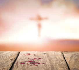 Good Friday concept: Blood on wood and blurred Jesus Christ on the cross sunset background