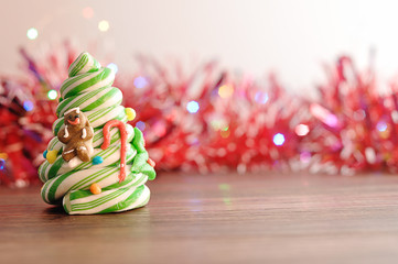 A candy cane Christmas tree displayed with out of focus tinsel and lights