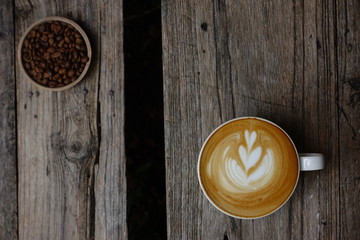 cup of latte art coffee on wooden background