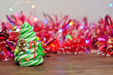 A candy cane Christmas tree displayed with out of focus tinsel and lights