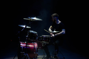 music, people, musical instruments and entertainment concept - male musician with drumsticks...
