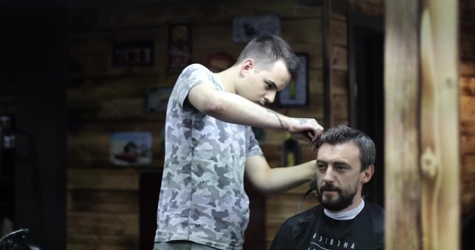 Hairdresser with tattooed hands working with customer.