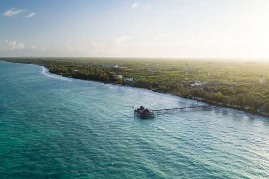 Aerial view of wooden pier on a tropical beach at sunset, Zanzibar island