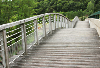 undulating wooden and metal walkway over river