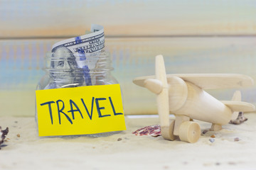 Planning for vacation, saving money for next trip. A toy plane on sand background