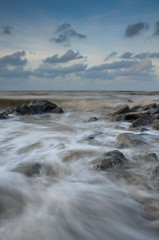 Fototapeta na wymiar Sea waves lash line impact rock on the beach