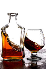Glass of splash whiskey with bottle.