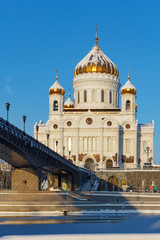 Fototapeta na wymiar Cathedral of Christ the Saviour on Patriarshiy Bridge background against the blue sky. Moscow in winter