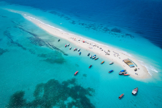 Aerial view of beautiful sand tropical island with white sand beach and tourists, Zanzibar