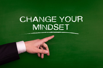 Businessman pointing CHANGE YOUR MINDSET word on blackboard