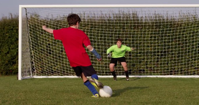A young boy scores a goal during a penalty shoot out. Shot in slow motion on RED Epic.