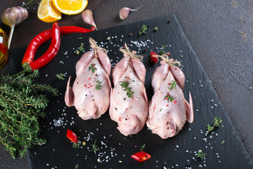 Fresh  raw meat quails ready for cooking on the  slate board