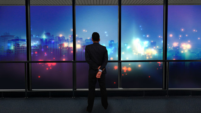 Businessman standing and looking at night city, Business vision concept