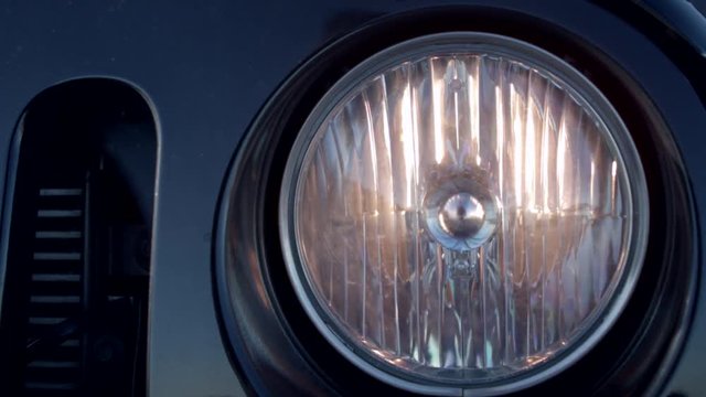 Closeup of the turning off headlight of a car.