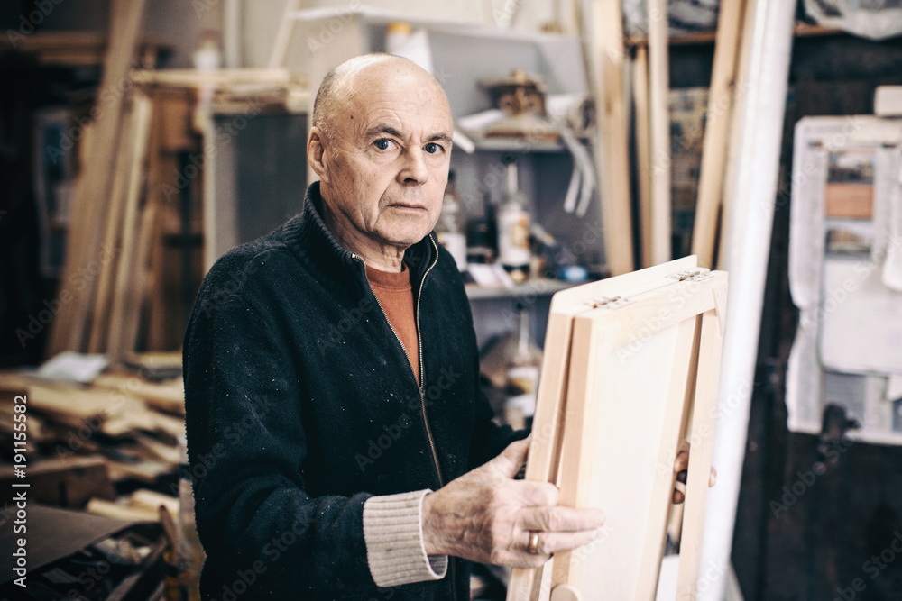 Wall mural Portrait of a carpenter with a new easel.