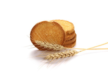 Integral wholewheat rusks, bread slices and ears of wheat isolated on white background