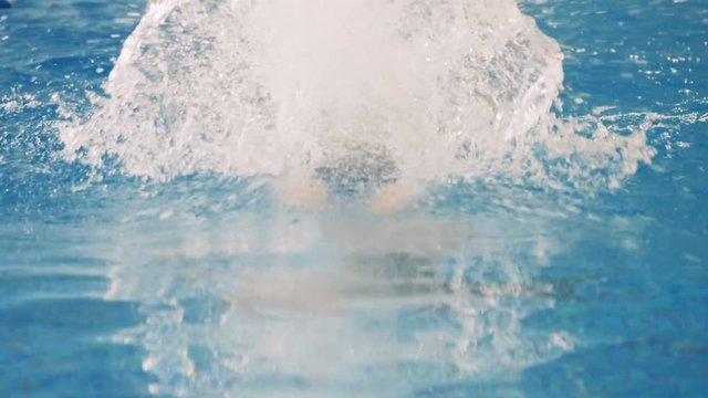 A female swimmer takes deep and fast breaths in a slow motion. 
