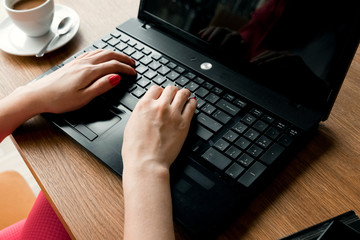 close-up office desk. Workspace with girl's hands, laptop, coffee cup. Business woman.