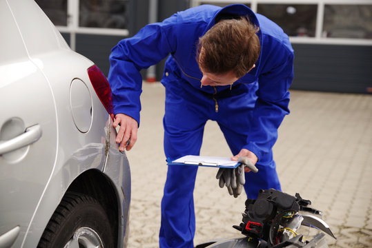 Gutachter inspiziert ein Auto mit Unfallschaden 