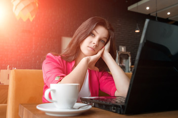 Fototapeta premium Young, beautiful girl, businesswoman, sitting in cafe and working on laptop. business lunch, cup of coffee, successful business woman.