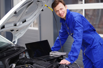 Mechaniker arbeitet mit einem Laptop an einem Auto, Motorsteuerung 