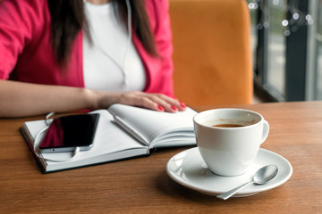 girl in headphones listening to music sitting in cafe. Break, business lunch, diary.