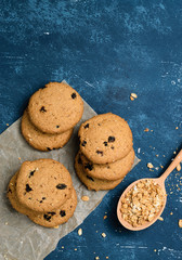 Delicious oatmeal cookies with raisins on concrete blue table background. Sweet pastry.
