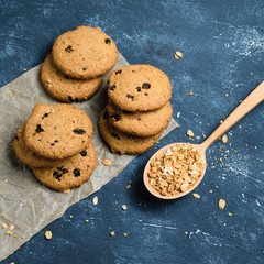 Delicious oatmeal cookies with raisins on concrete blue table background. Sweet pastry.