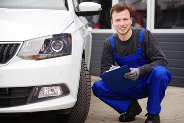 Mechaniker bei der Durchsicht eines Autos, TÜV-Untersuchung 