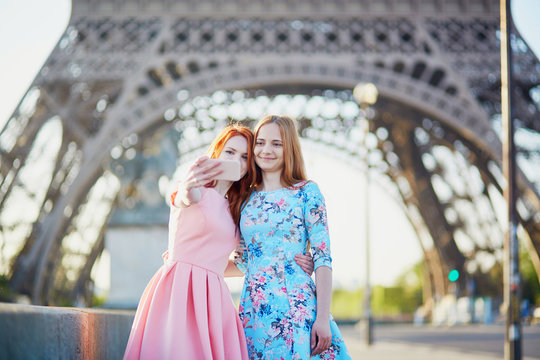 Two friends taking selfie near Eiffel tower in Paris, France