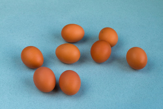 A groul of brown eggs on a blue background