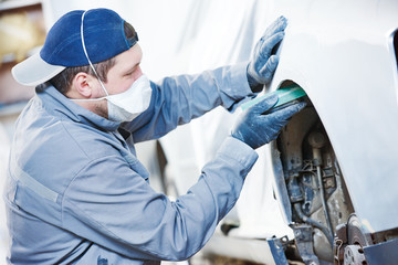 auto repairman grinding autobody bonnet