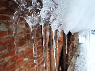 Naklejka na ściany i meble icicles in winter, and in the background landscape, macro
