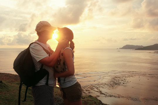 Romantic couple embracing and kssing at sea sunset.