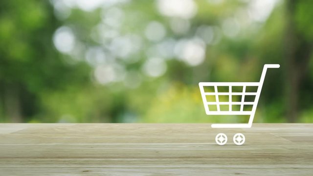 Shopping cart icon on wooden table over blur green tree background, Shop online concept