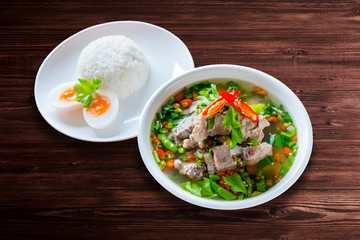 Spicy Pork with Pork bone Soup with Rice and Egg on the Wood Table.