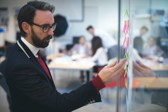 Business executive looking at sticky notes