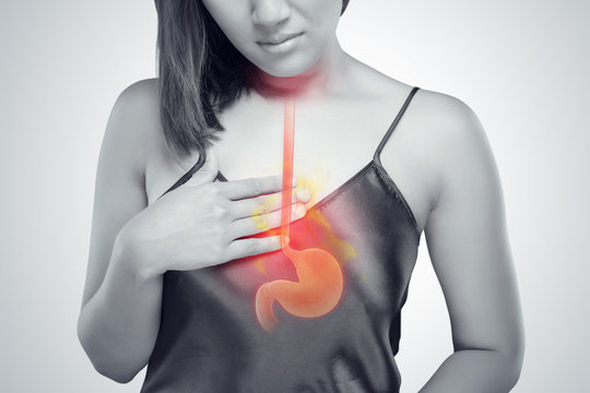 The photo of stomach is on the woman's body against gray Background, Acid reflux or Heartburn, Female anatomy concept