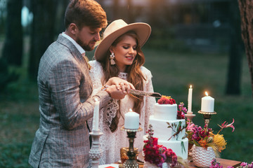 beautiful happy couple cutting wedding cake