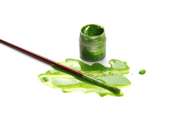 Spilled green watercolor with bottle and paintbrush isolated on white background