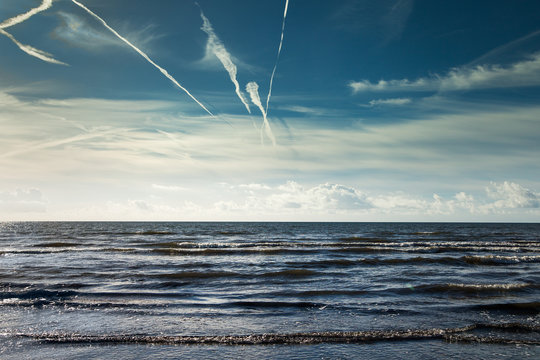 Plane trails above Baltic sea.