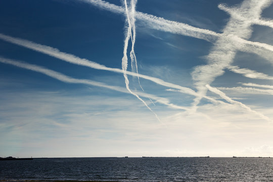 Plane trails above Baltic sea.