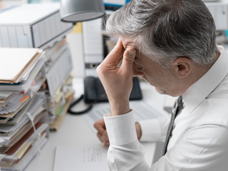 Businessman working in the office and piles of paperwork