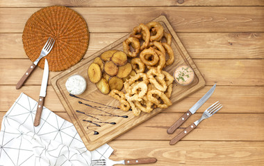 Onion rings with batter and fried potatoes