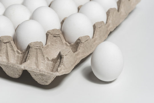 White chicken eggs in a cardboard package, background