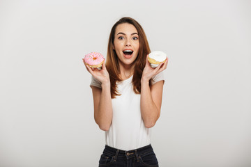 Portrait of a happy young woman holding donuts