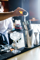 barman is making cocktail at night club