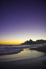 Dark dusk sunset scenic view of Ipanema Beach with Two Brothers Mountain on the Rio de Janeiro, Brazil city skyline 